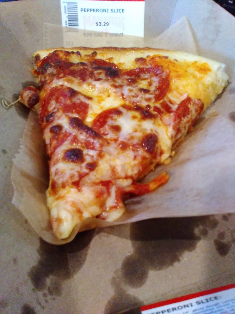 Photo of a slice of pepperoni pizza on a cardboard tray.